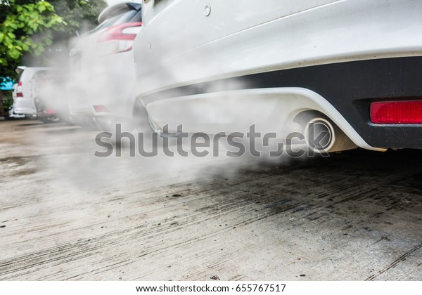 Incomplete combustion\
creates poisonous carbon monoxide from exhaust pipe of white car,\
air pollution\
concept.