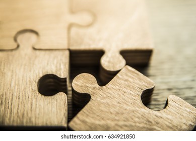 Incomplete puzzles on wooden table background. closeup. Puzzles on wooden table, close up.