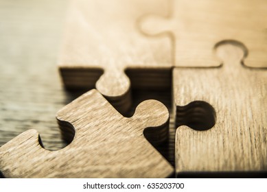 Incomplete puzzles on wooden table background. closeup. Puzzles on wooden table, close up.