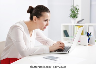 Incorrect posture concept. Young woman sitting at table in modern room