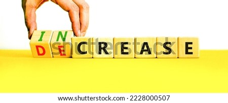 Increase or decrease symbol. Concept words Increase and Decrease on wooden cubes. Businessman hand. Beautiful yellow table white background. Business increase or decrease concept. Copy space.