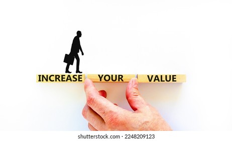 Increase your value symbol. Concept words Increase your value on wooden blocks on a beautiful white table white background. Businessman hand. Business increase your value concept. Copy space.