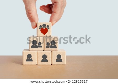 Increasing customer loyalty, Developing strategies to create relationships with customers ,understanding customer needs and providing values. hand hold top of pyramid wood cube blocks with men icons