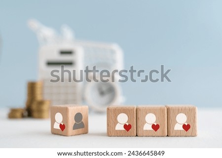 Increasing customer loyalty, Developing strategies to create relationships with customers ,understanding customer needs and providing values. Wood cube blocks with men and heart icons , blurred coins