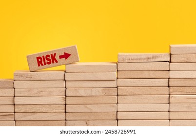 Increasing or growing risk level and risk taking in business concept. Wooden block with the word risk climbing the staircase of wooden blocks.