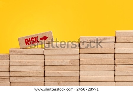 Increasing or growing risk level and risk taking in business concept. Wooden block with the word risk climbing the staircase of wooden blocks.