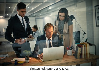 Increasing productivity with teamwork and extra hours. Shot of a team of colleagues using a laptop together on a night shift at work. - Shutterstock ID 2167142729