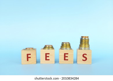 Increasing, raising and high fees concept. Stack of coins in wooden blocks with word fee.