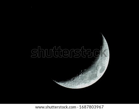 Similar – Image, Stock Photo Increasing crescent moon in dark blue evening sky with light clouds, moon craters and moon seas are visible