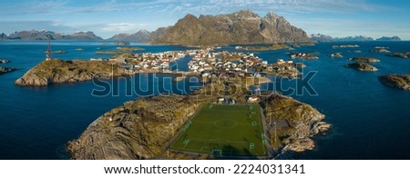 Incredible aerial view of Henningsvaer, its scenic football field and mountains in the background. A small fishing village located in Lofoten Islands, Norway.