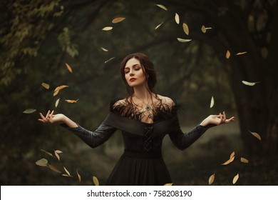 Incredible, amazing, seductive girl, in a  dress , magic rotates the leaves. The background is fantastic autumn. Artistic photography.