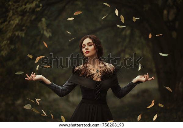 素晴らしく魅力的な女の子がドレスを着て 魔法で葉を回転させます その背景は幻想的な秋です 芸術的な写真 の写真素材 今すぐ編集
