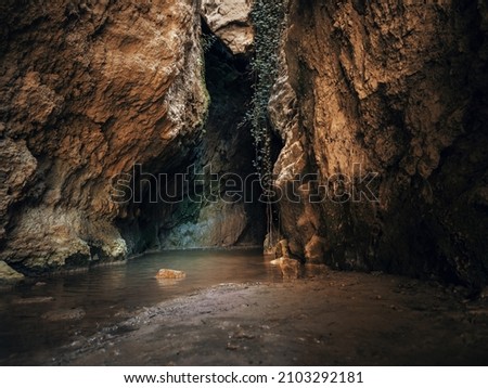 Incredible cave located in Moratalla; Light rays filter through the rocks and a small river that runs through the cave. Mediterranean city, arid nature. Rocks in a cave with light. Spain.