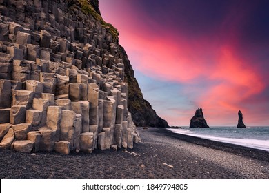 Incredible view on Black beach and Troll toes cliffs in sunset time. Great purple sky glowing on background. Reynisdrangar, Vik, Iceland. Landscape photography - Powered by Shutterstock