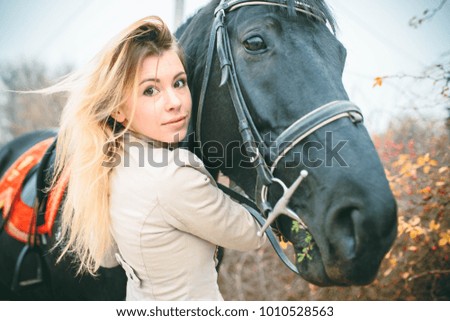 Incredibly beautiful woman with luxurious hair walks with a horse