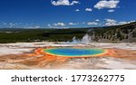 the incredibly colorful grand prismatic hot springs in midway geyser basin on a sunny day as seen from a viewpoint on a hillside at yellowstone national park, wyoming