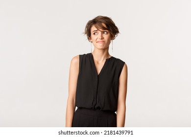 Indecisive Brunette Girl Smirk And Looking Left With Doubtful Expression, Hesitating Over White Background