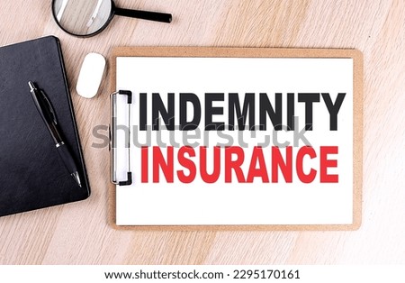 INDEMNITY INSURANCE text on a clipboard on wooden background
