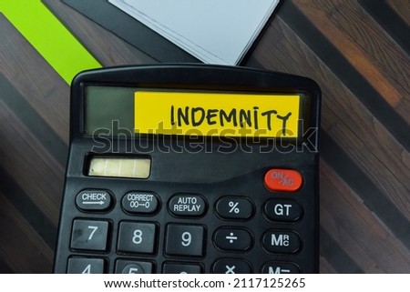 Indemnity write on sticky notes isolated on Wooden Table.