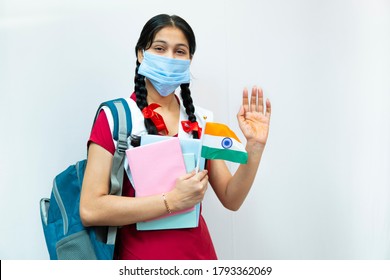 Independence Day (15 august) - happy Indian teenager girl in school uniform with braided hair  holding books, waving hands, wearing protective surgical face mask of Indian flag. - Powered by Shutterstock