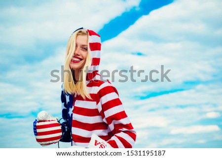 Independence Day. 4th of July. Happy cute girl with American flag. Happy young girl waving American flag outside on sky background. Her clothes with strip and stars