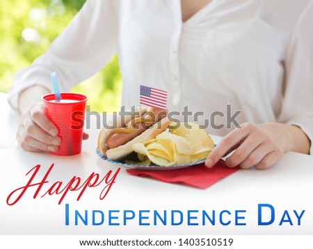 independence day, celebration, patriotism and holidays concept - close up of woman with hot dog decorated by american flag, chips and juice at 4th july party over natural summer green background