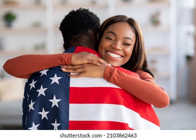 Independence Day. Happy Black Wife Embracing Husband Wrapped In American Flag, Cheerful Millennial Woman Celebrating Reunion With Her Military Spouse After Returning From Army, Closeup Shot - Powered by Shutterstock