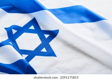 Independence Day of Israel. National Israel flag with star of David over white wooden background. Close up. National flag with place for text.