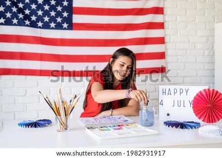 Independence day of the USA. Happy July 4th. Beautiful woman drawing a watercolor illustration for Independence day of the USA.