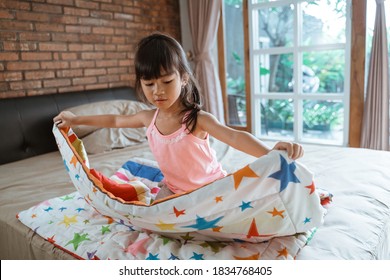 Independent Asian Child Make Up Her Room And Fold The Blanket