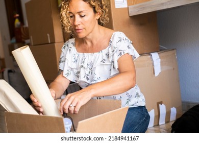 Independent Woman Organizing House Moving Putting Objects In A Cardboard Carton Box. Happy Woman Enjoy Leisure Indoor Activity After Loan Mortgage Home Buy. Concept Of New Property And Future