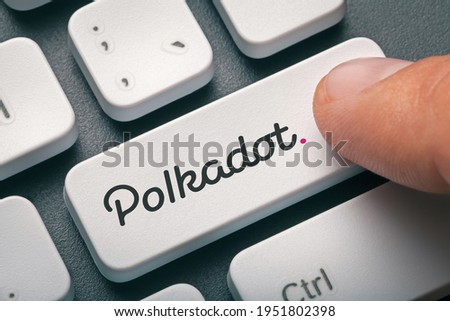 Index finger of male hand pressing computer key with Polkadot | Dot logo. Cryptocurrency mining, trading, market concept.