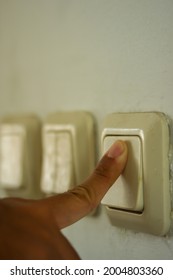 The Index Finger Of A Man Is Turning Off The Light Switch