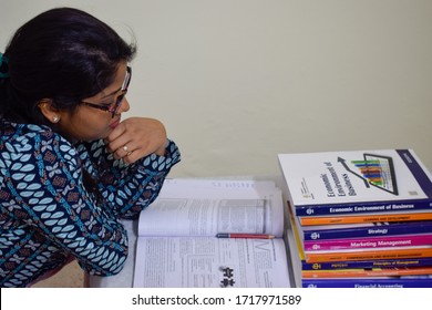 India 2020 : Girl With Eye Glasses Studying During Exam Time. Books Of Various Subjects Are Kept On The Table. She Is Holding A Pencil And Highlighting The Important Topics