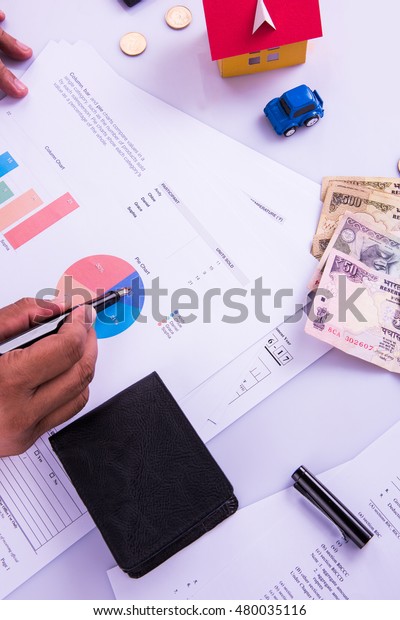 India and accounting concept showing
accountant working on Income tax forms or on budget planning with
currency notes, calculator and house/car 3d
Models