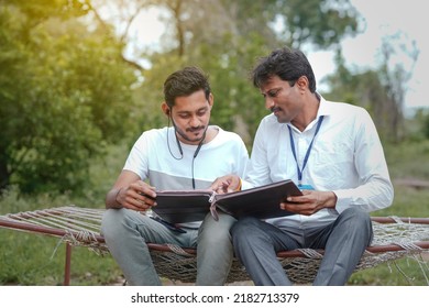 India Bank Officer Completing Paper Work With Youngster At Home