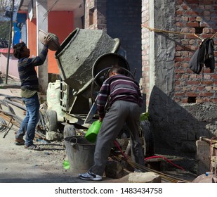 India, Dharamsala - March 11, 2018: The Indian Construction Industry. Workers Prepare A Grout In A Concrete Mixer, Homebuilding