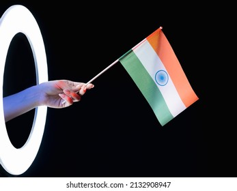 India Flag. Patriotic Symbol. Culture Pride. Female Fan Hand Holding Tricolor With Orange White Green Horizontal Stripes In Glowing LED Light Ring Isolated On Black Background.