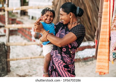 India, Goa, the village of Benaulim  - November 15, 2012: Unidentified Indian woman and baby in her arms are smiling with very good mood. A mother and her child