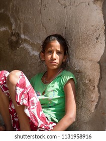 India, Pushkar-March 3, 2018: Girl Jillaroo In Simple Dress Sitting On Footpath With An Unhappy Look, Poor Teenager