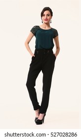 Indian Arabian Eastern Brunette Business Executive Woman With Updo Hair Style In Trousers And T-shirt High-heeled Shoes Full Length Body Portrait Standing Isolated On White