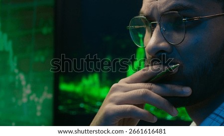 Indian Arabian man programmer coder hacker male guy trader IT specialist thoughtful analyst thinking analysing cryptocurrency financial chart graph solve ponder hesitate broker looking monitor indoor