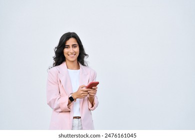 Indian or arabic woman in business suit holding cellphone, looking at camera. Happy young middle eastern businesswoman using smartphone mobile phone for work isolated on white background. Copy space