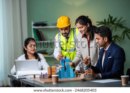 Indian asian Architect, builder and engineer meeting together and discussing city planning on table