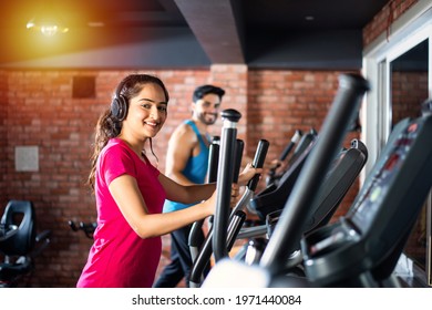 Indian Asian Attractive Couple Doing Cardio Training Program In Fitness Center Or Gym, Selective Focys - Health And Fitness Concept