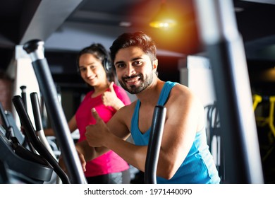 Indian Asian Attractive Couple Doing Cardio Training Program In Fitness Center Or Gym, Selective Focys - Health And Fitness Concept