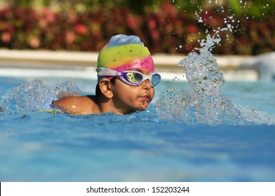 Indian asian Boy in the swimming pool with goggles in Arab resort - Powered by Shutterstock