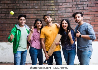 Indian Asian College Students Or Friends Playing Cricket Match As Outdoor Sport Activity