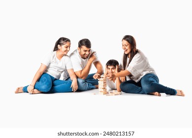 Indian asian family playes wooden block stacking game at home together and having fun - Powered by Shutterstock