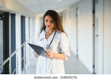 An Indian Asian Female Medical Doctor In A Hospital Office With Stethoscope.